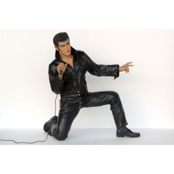 Junger hockender Elvisdouble singend mit Mikrofon lebensgroß