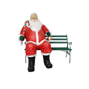 sitzender dicker Weihnachtsmann auf Bank mit Glocke und Zuckerstange lebensgroß