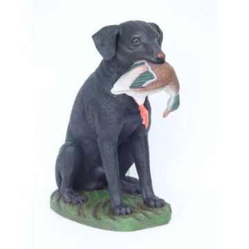 Jagender schwarzer Hund mit Ente lebensgroß