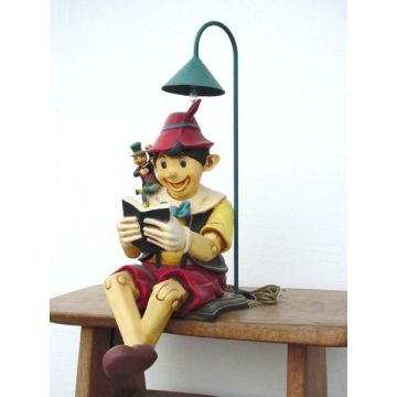 Pinocchio lesend mit Lampe lebensgroß
