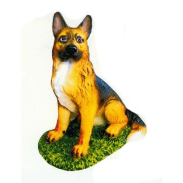 Schäferhund sitzend auf Wiese lebensgroß