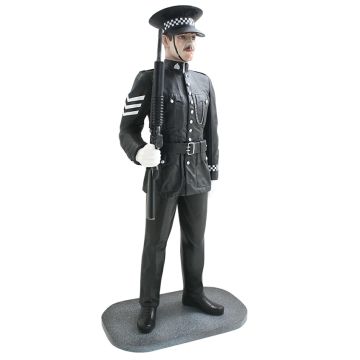 Britischer Polizist mit Waffe lebensgroß